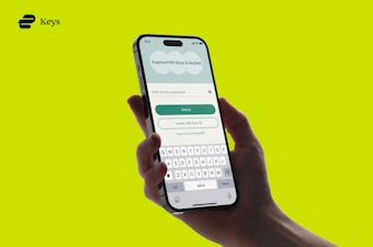 Handing holding a phone showing the ExpressVPN Keys UI.