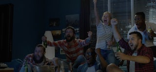 People cheering watching sports on TV.