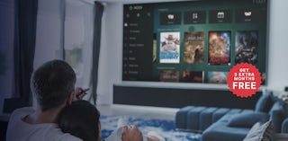 ソファでテレビを観ているカップル。12+3のバッジがあるKodiヒーロースーパーデスクトップ。