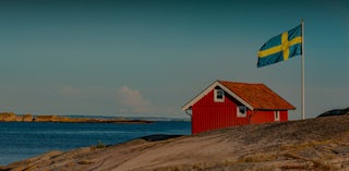 Sweden IP address: Background photo of a red house with a Swedish flag.