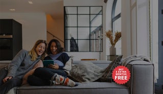Women on couch looking at device. Hulu hero super desktop with 12+3 badge.