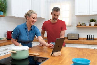 Imagem de estilo de vida do ExpressVPN Aircove na cozinha com duas pessoas.