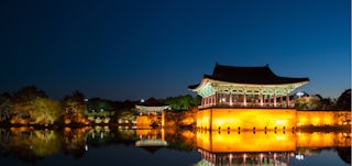 South Korean temple at night, reflected in water