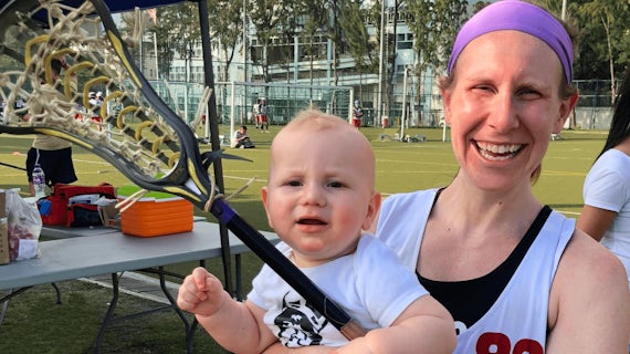 Kate with her child and a lacrosse stick